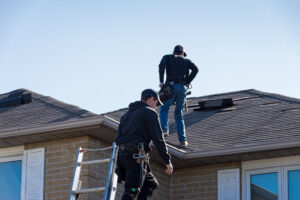 Roof Leak Repair. Two Roofers Inspecting A Damaged Roof.