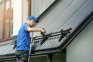 Ottawa Roofing. Roofer Installing Snow Guard On Metal Roof.