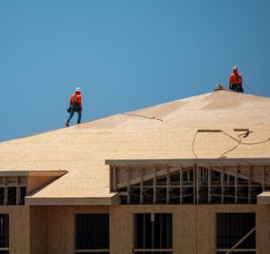 Godfrey Roofing. Roof,Construction.,Roofer,On,Roof,Structure.,Construction,Worker,On,Top