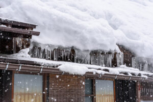 Roofing Solutions for Winter Damage. Ice dams and heavy snow of roof of home.