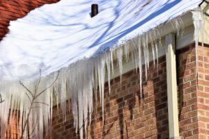 Fix Winter Damage With Godfrey Roofing: Ottawa Roofing Experts. Ice build up in roof gutters creating a dam against drainage.