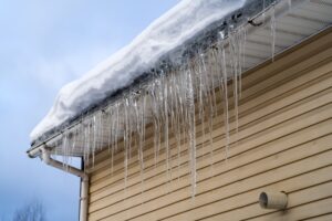 Roofing Contractors. Icicles on roof of private house resulting from improper construction of roof.